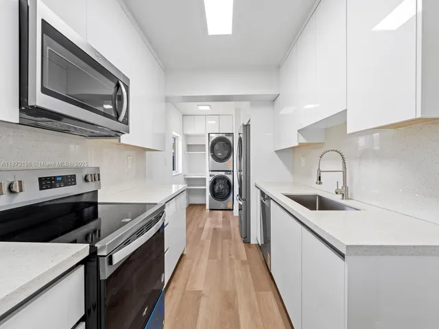 a kitchen with stainless steel appliances a sink stove and microwave