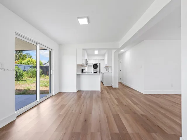 a view of a kitchen with wooden floor and a refrigerator