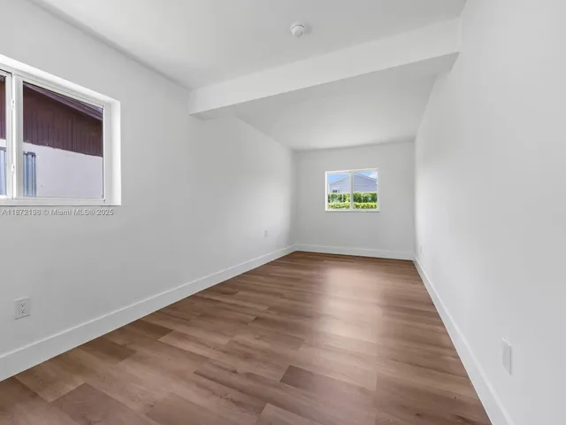 a view of a house with a big yard and potted plants