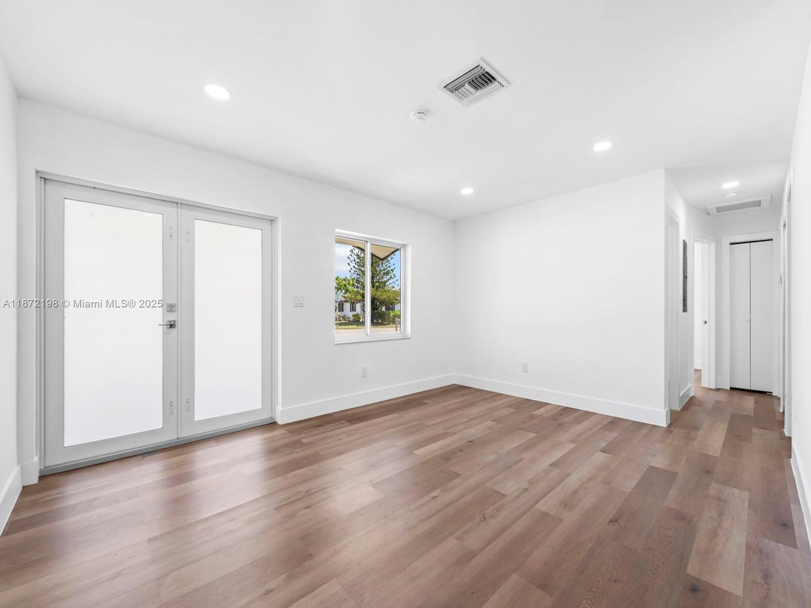 10530 Southwest 146th Street Miami, FL 33176 - Photo 5 of 54 an empty room with wooden floor and windows