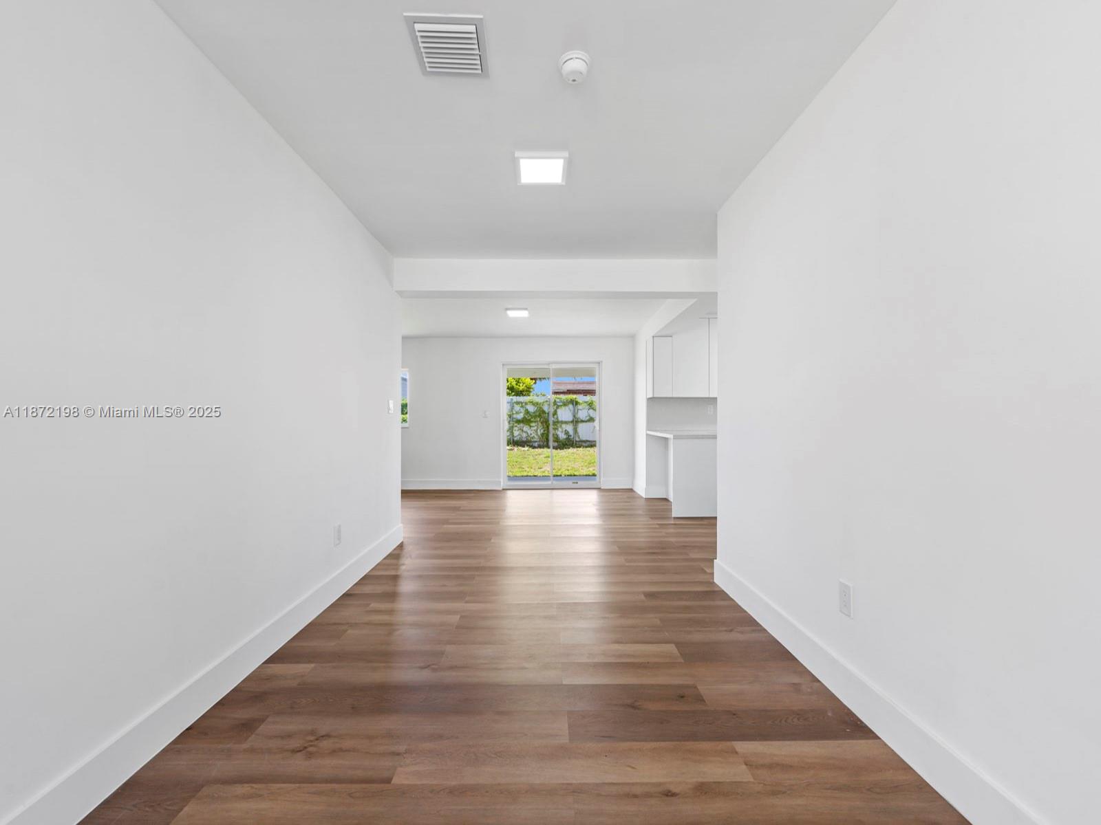 10530 Southwest 146th Street Miami, FL 33176 - Photo 7 of 54 a view of an empty room with wooden floor and a window