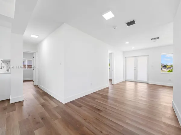 a view of a kitchen with wooden floor and a window