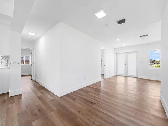 a view of a kitchen with wooden floor and a window