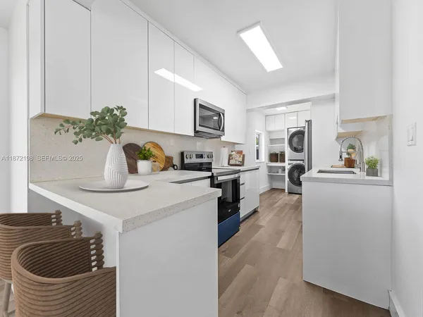 a kitchen with a sink dishwasher a stove and a refrigerator with wooden floor