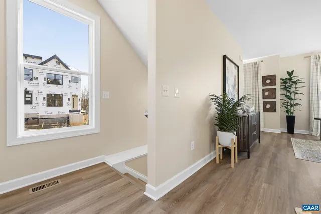 a view of a room with wooden floor and a potted plant