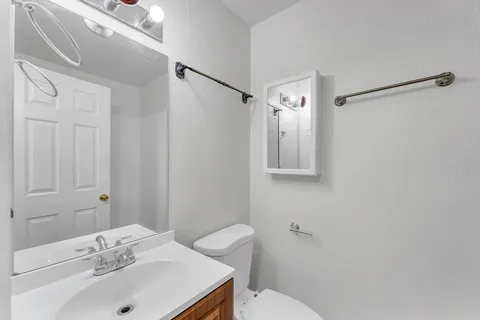 a bathroom with a sink mirror and toilet