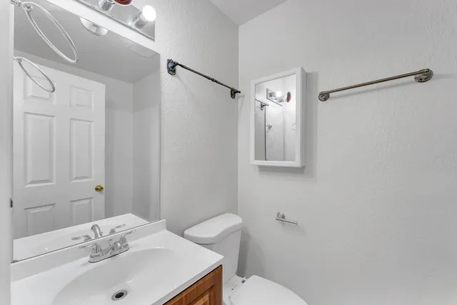 a bathroom with a sink mirror and toilet