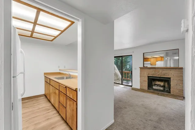 a view of an empty room with fire place and a window
