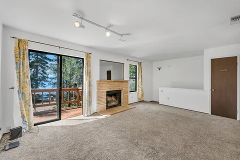 wooden floor fireplace and windows in an empty room