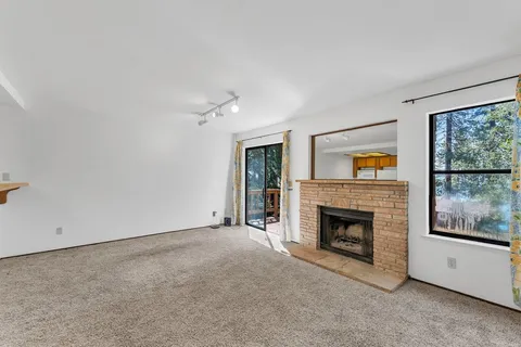 a view of empty room with fireplace and fan