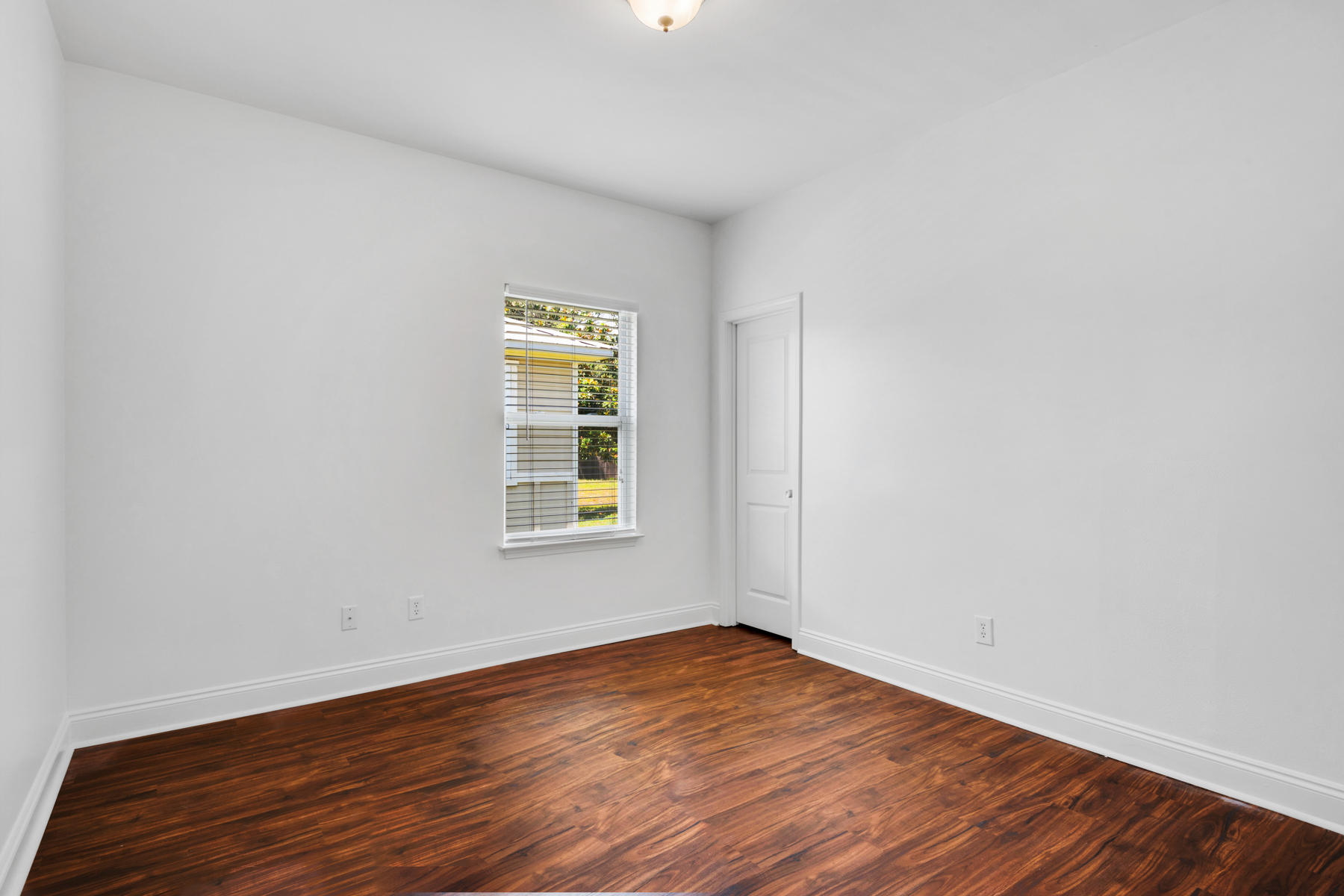 249 County Line Road Niceville, FL 32578 - Photo 10 of 17 an empty room with wooden floor and windows