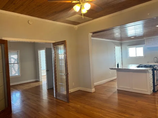 a view of a hallway with wooden floor and a chandelier