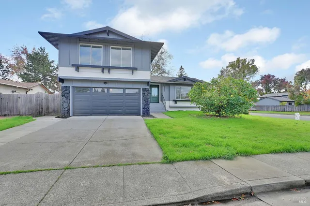 a front view of a house with a yard and a garage