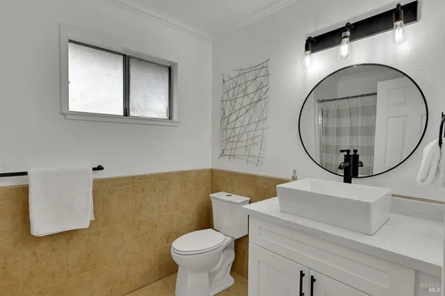 a backyard of a house with large trees and wooden fence