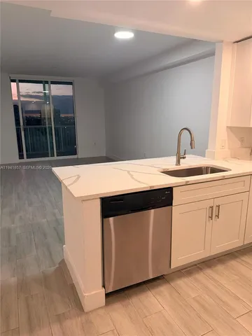 a kitchen with a sink cabinets and wooden floor
