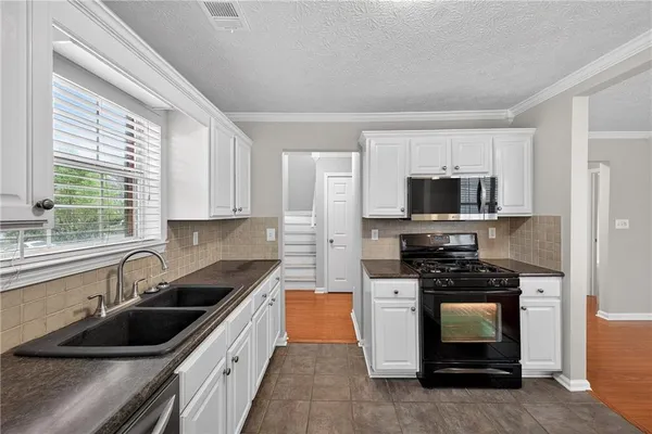 a kitchen with stainless steel appliances a stove sink microwave and cabinets