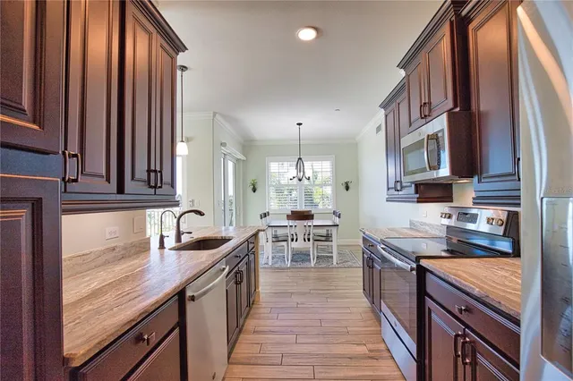 a kitchen with stainless steel appliances granite countertop a sink stove and cabinets