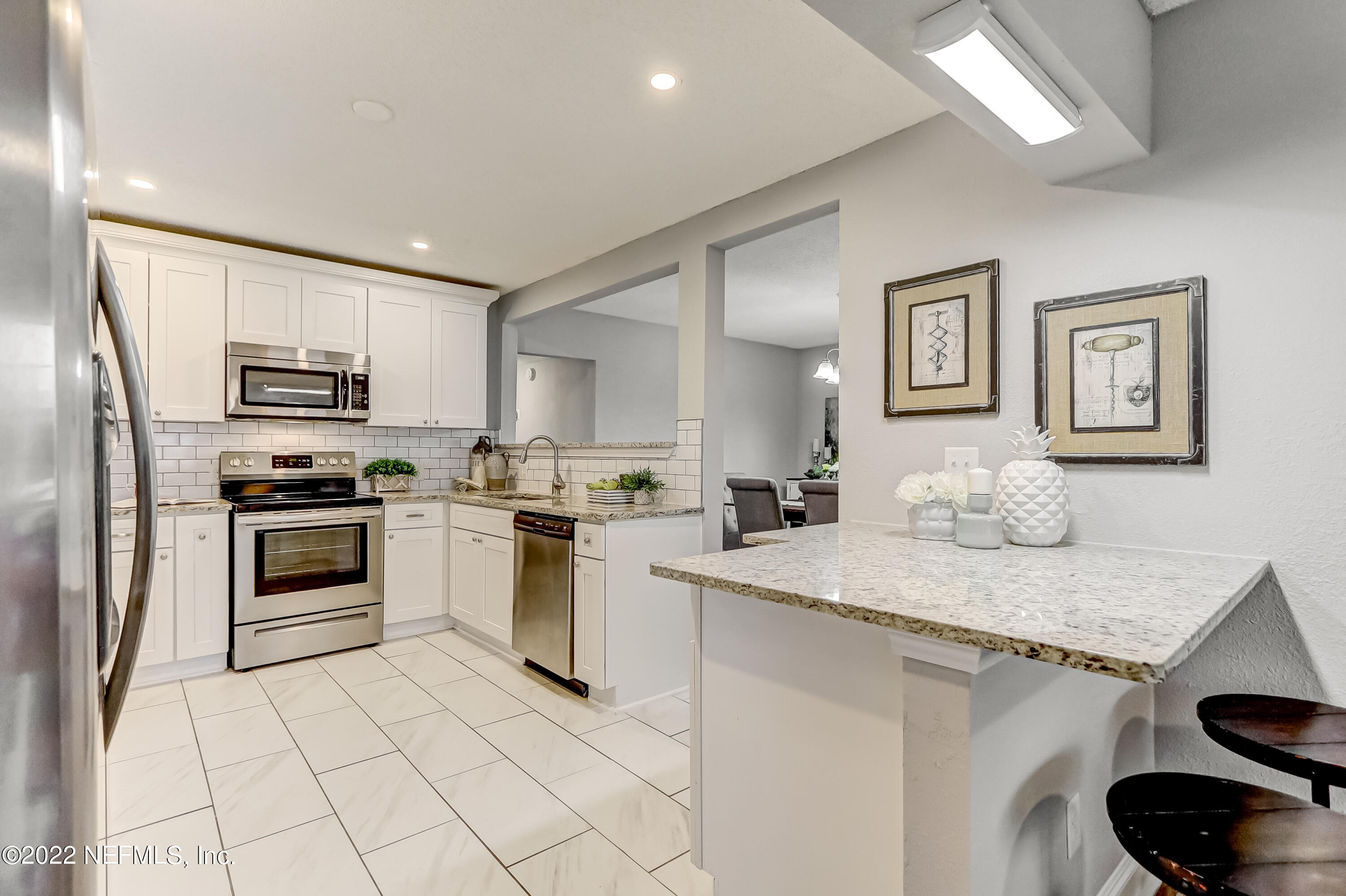 3607 Basil Road Jacksonville, FL 32207 - Photo 1 of 31 a kitchen with granite countertop white cabinets and stainless steel appliances