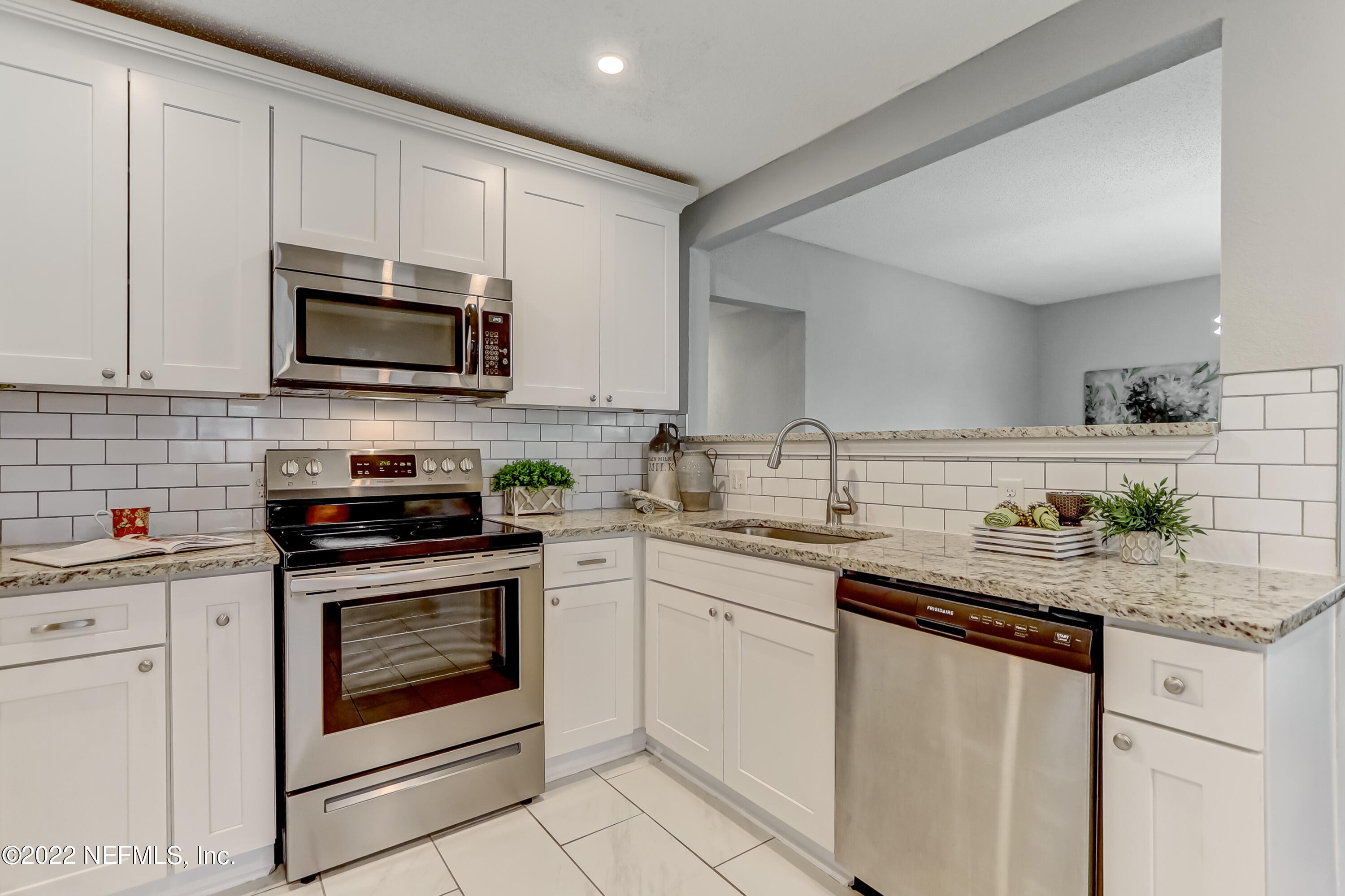 3607 Basil Road Jacksonville, FL 32207 - Photo 13 of 31 a kitchen with granite countertop white cabinets white stainless steel appliances and a sink