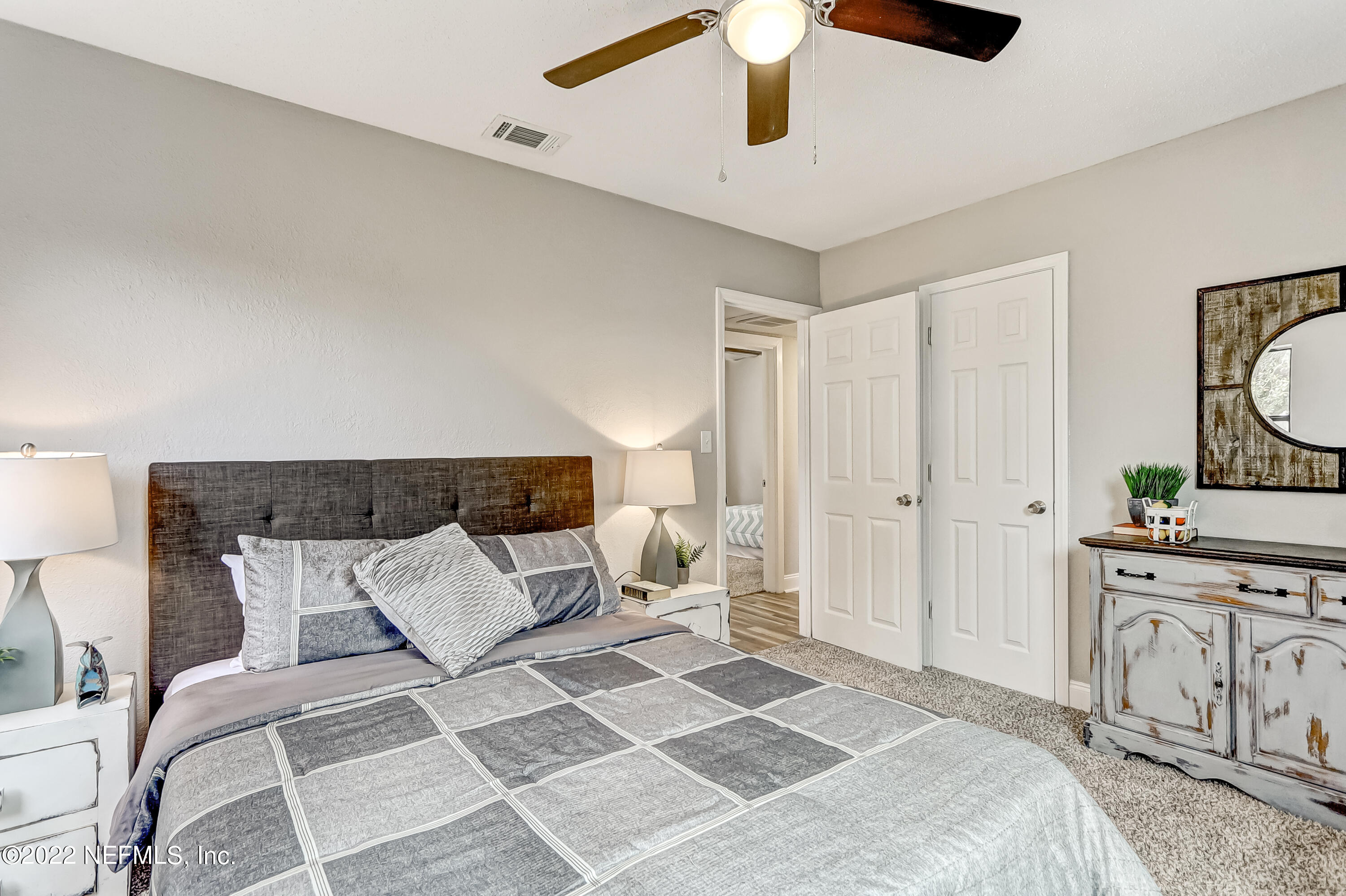 3607 Basil Road Jacksonville, FL 32207 - Photo 25 of 31 a bedroom with a bed and a chandelier