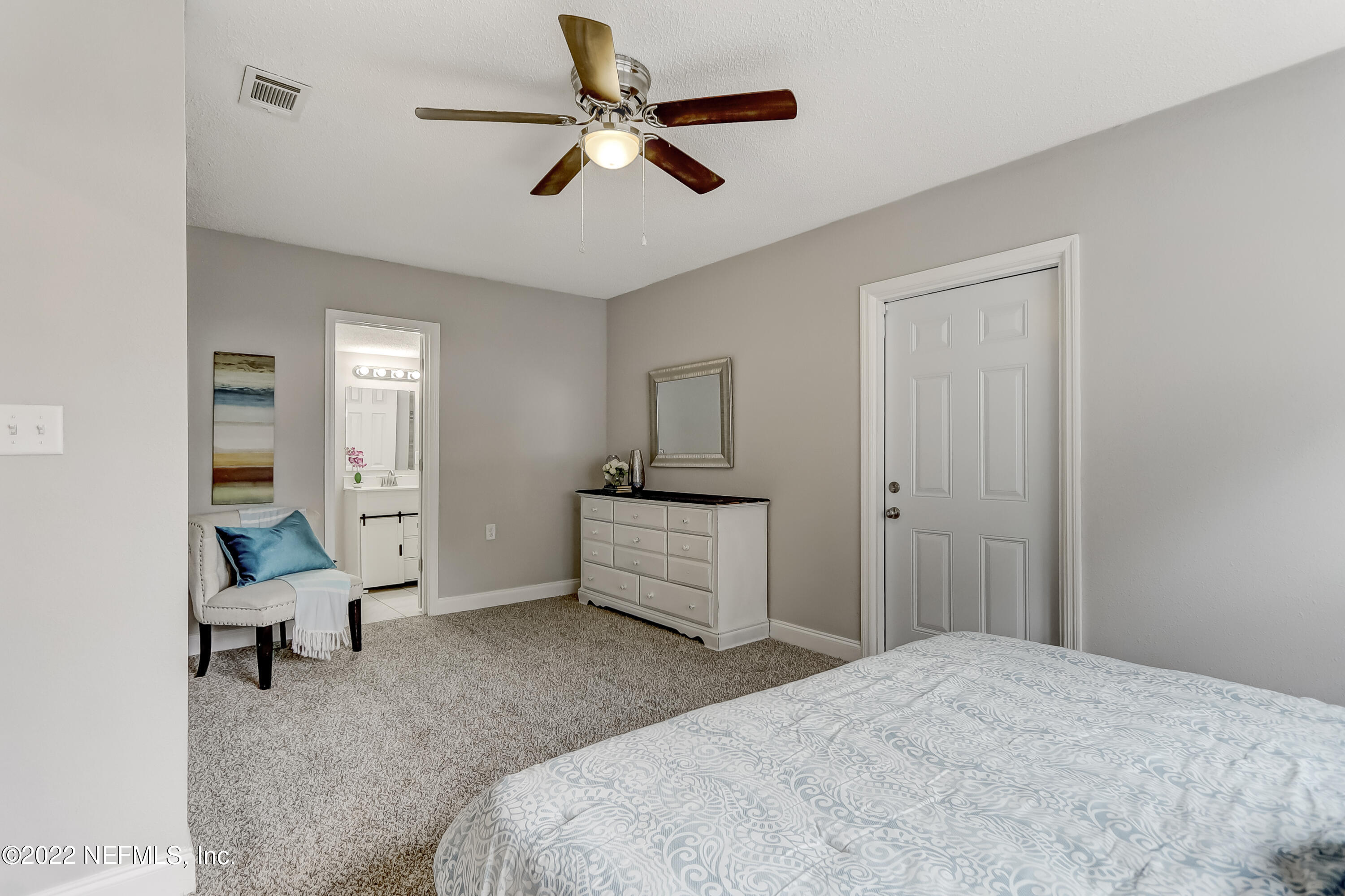 3607 Basil Road Jacksonville, FL 32207 - Photo 27 of 31 a bedroom with a bed and a chandelier