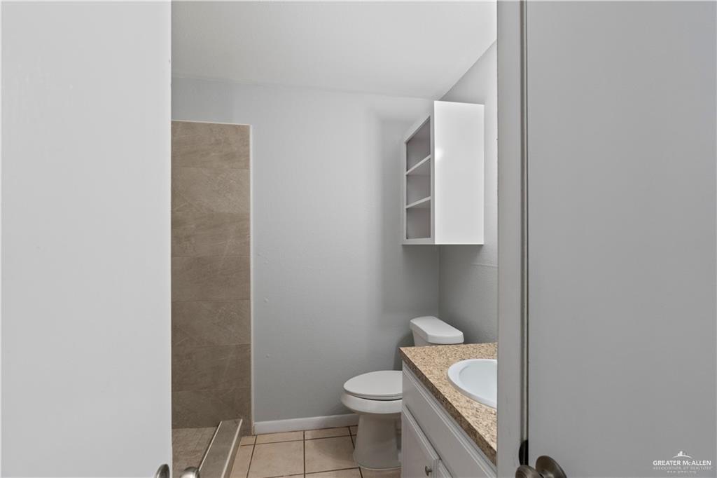 1701 West McIntyre Street, Unit 5 Edinburg, TX 78542 - Photo 11 of 15 Bathroom featuring vanity, light tile patterned flooring, and tiled shower