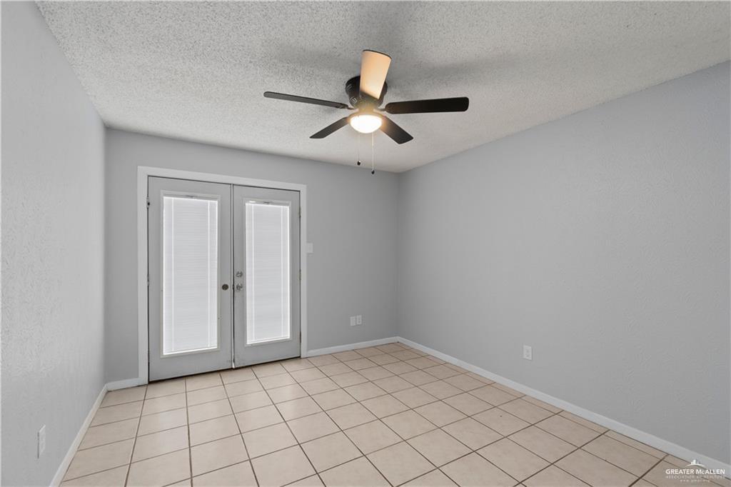 1701 West McIntyre Street, Unit 5 Edinburg, TX 78542 - Photo 12 of 15 Empty room featuring french doors, a textured ceiling, light tile patterned floors, and ceiling fan