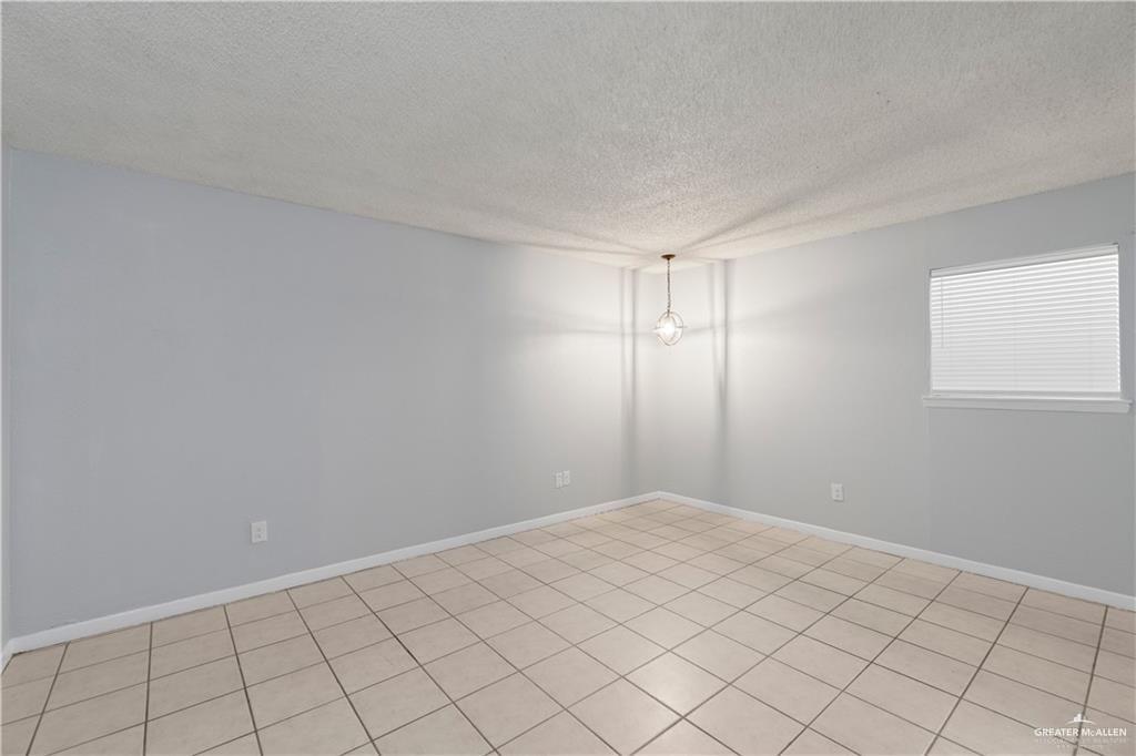 1701 West McIntyre Street, Unit 5 Edinburg, TX 78542 - Photo 15 of 15 Unfurnished room with a textured ceiling and light tile patterned flooring