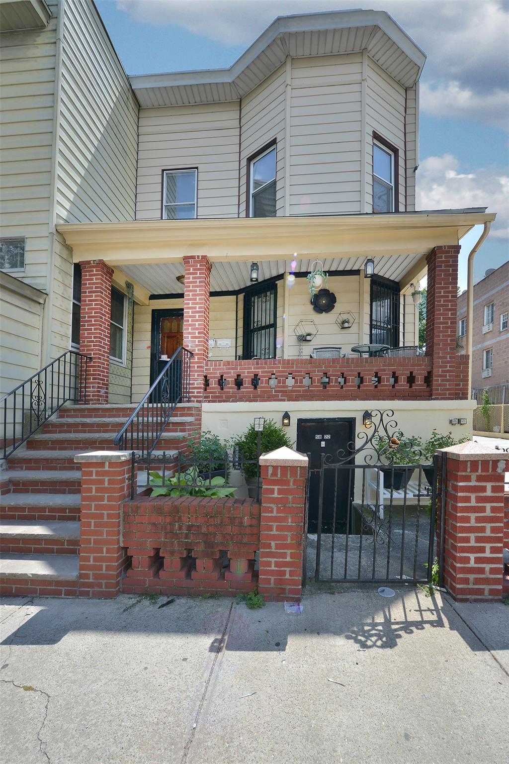 58-22 Penrod Street Queens, NY 11368 - Photo 1 of 1 View of front of house with a fenced front yard, covered porch, stairs, a gate, and brick siding