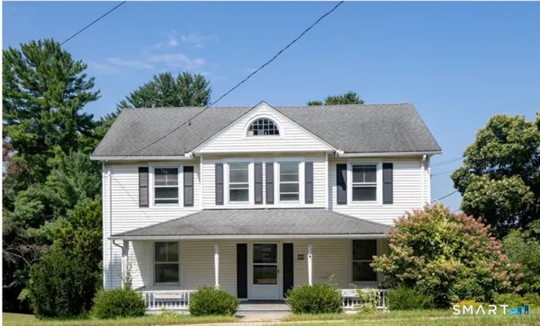 a front view of a house with a yard and potted plants