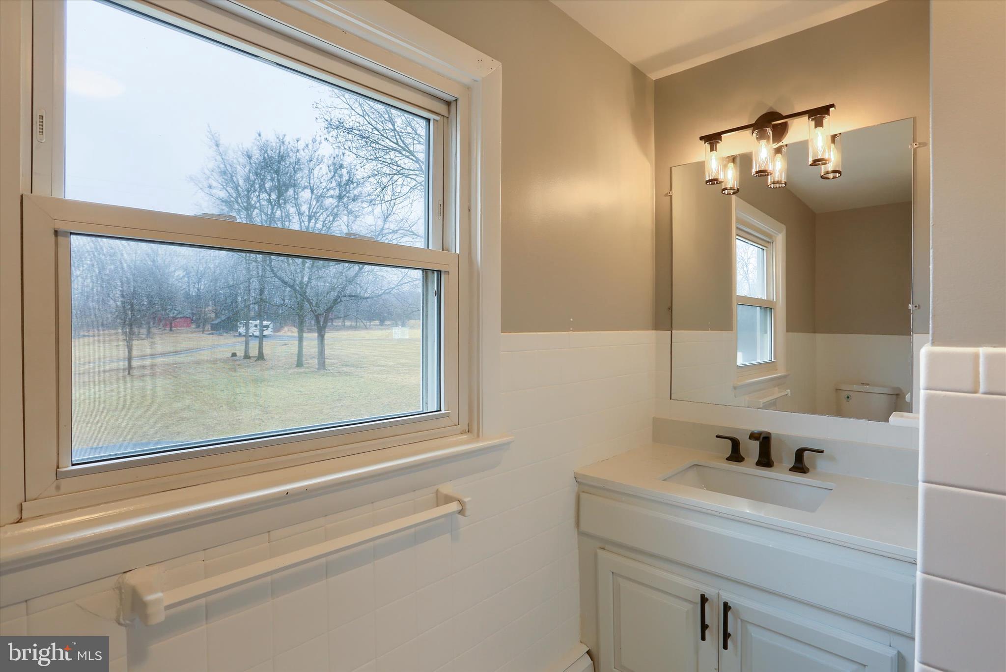 685 Knight Road Harrisburg, PA 17111 - Photo 31 of 47 a bathroom with a sink a large mirror and a window