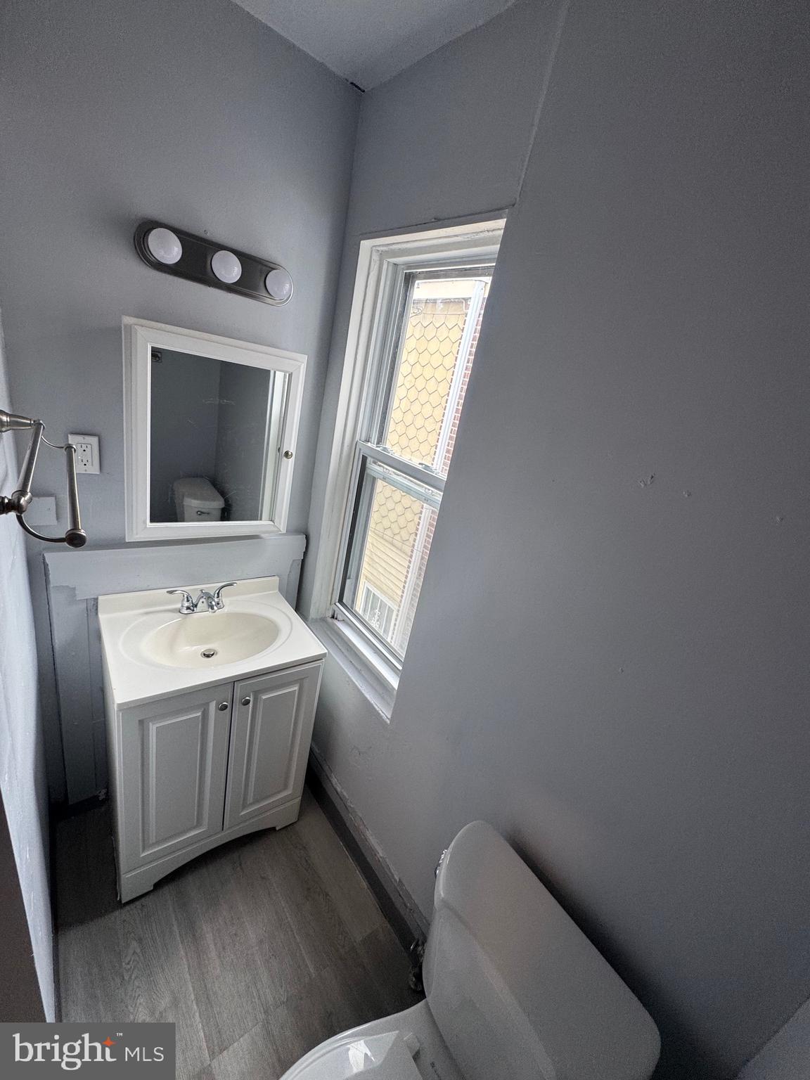 3003 Washington Street Wilmington, DE 19802 - Photo 14 of 18 a bathroom with a granite countertop toilet a sink and a mirror