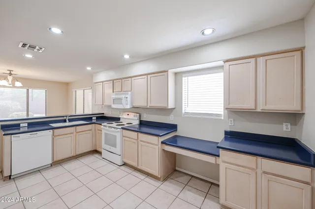 a kitchen with granite countertop white cabinets and white appliances
