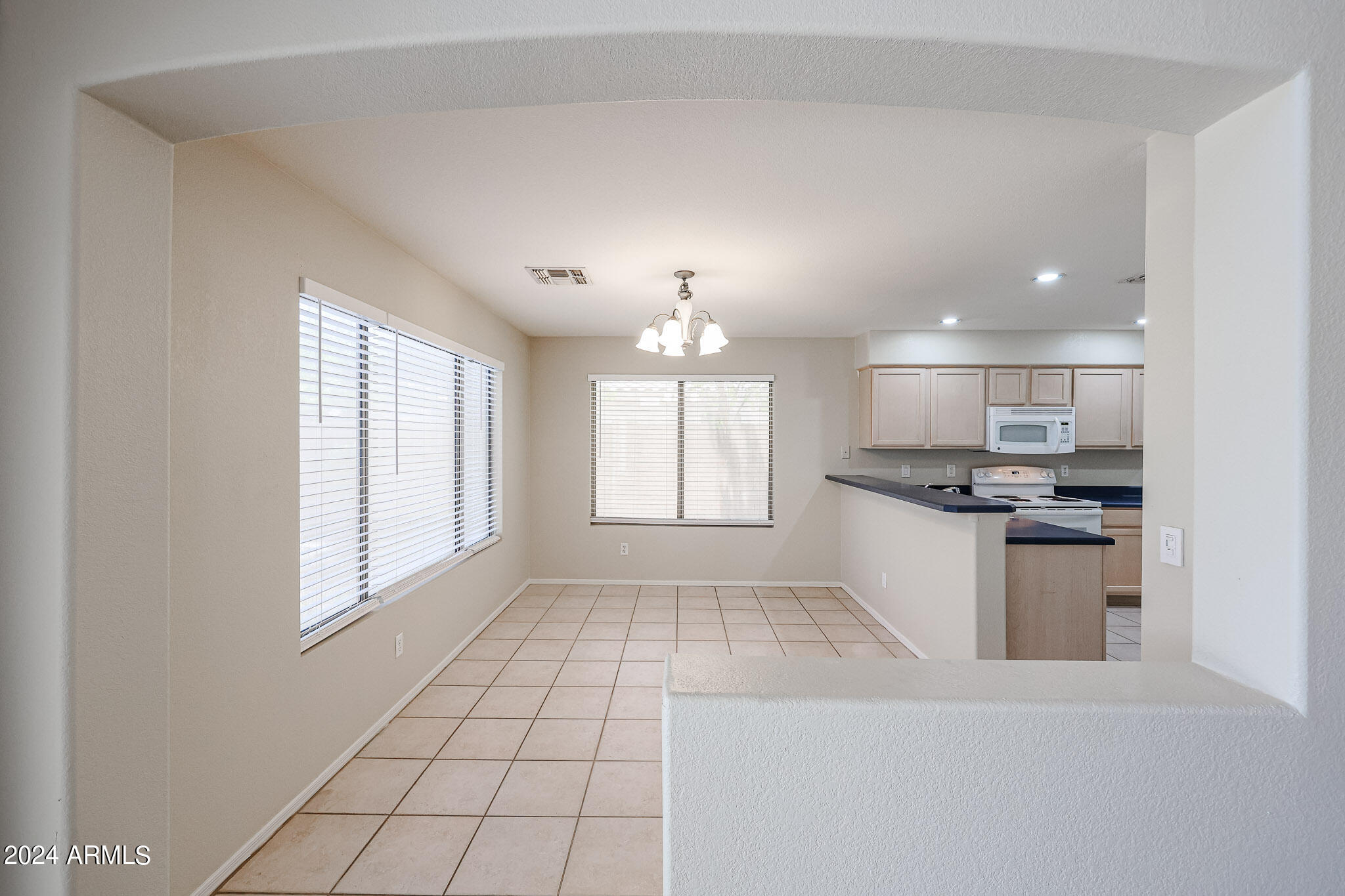 6921 West Juniper Avenue Peoria, AZ 85382 - Photo 17 of 33 a kitchen with kitchen island granite countertop a stove and a sink