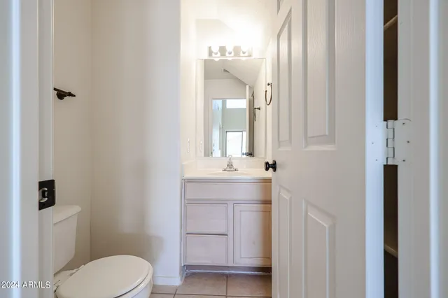a bathroom with a toilet a sink a mirror and vanity