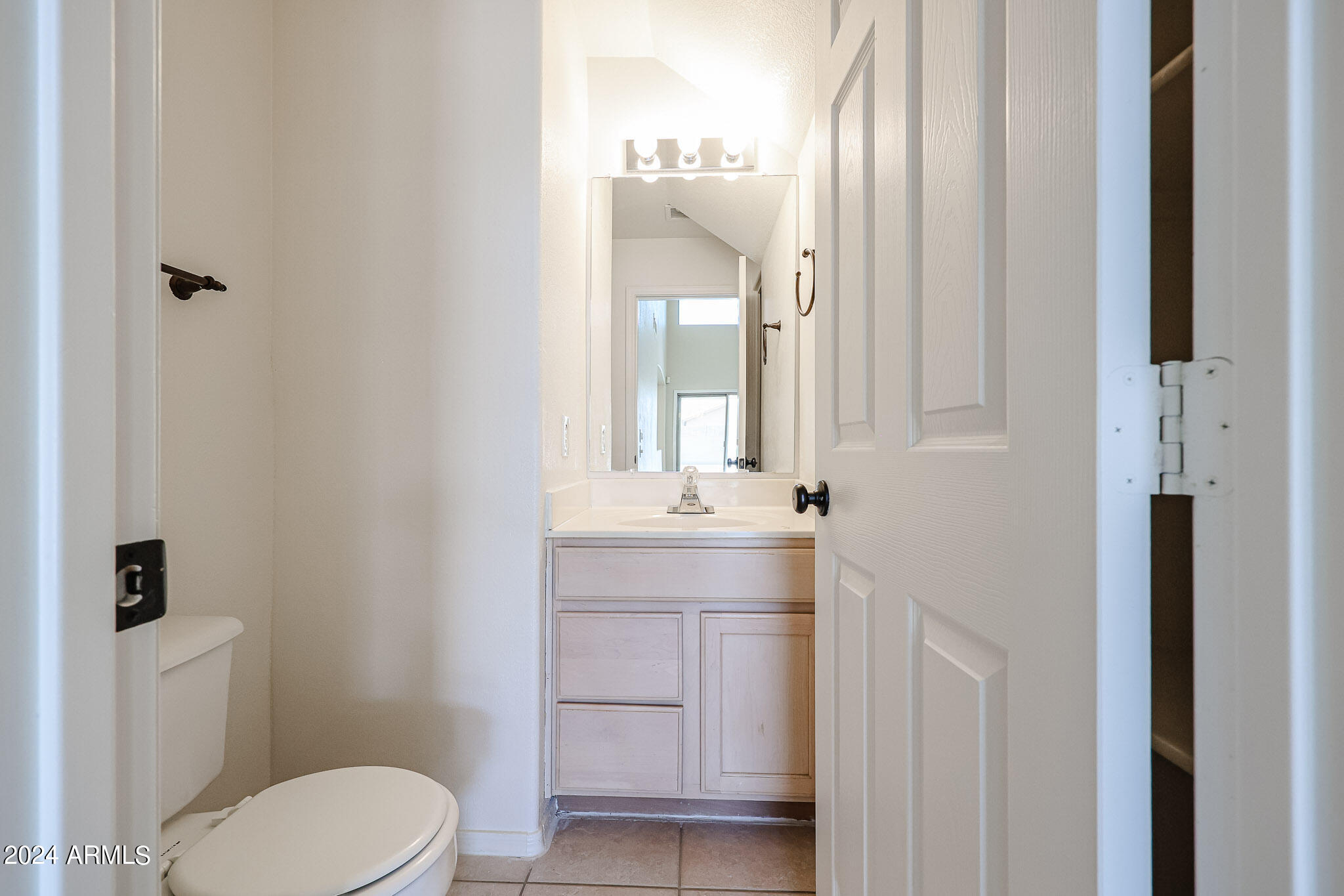 6921 West Juniper Avenue Peoria, AZ 85382 - Photo 18 of 33 a bathroom with a toilet a sink a mirror and vanity