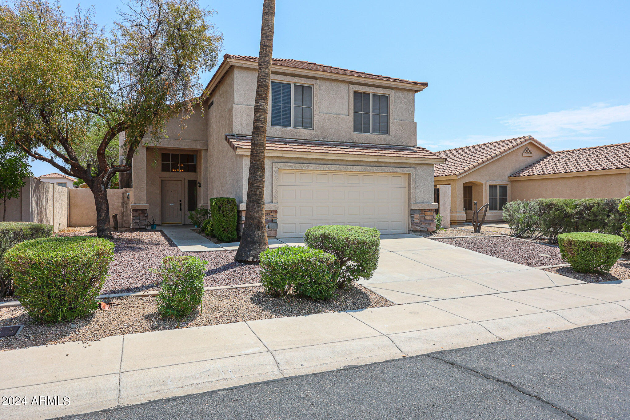6921 West Juniper Avenue Peoria, AZ 85382 - Photo 3 of 33 a front view of a house with a garden and plants