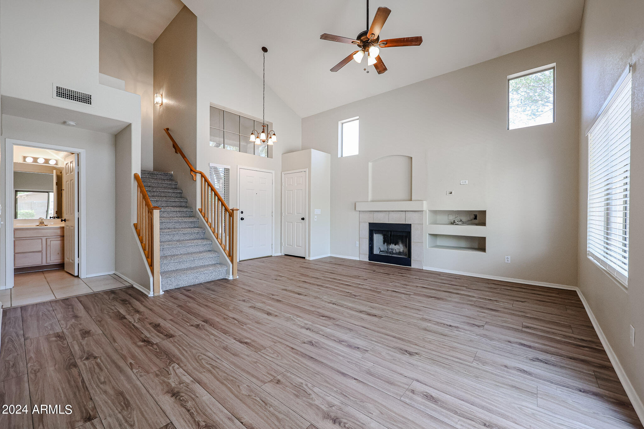 6921 West Juniper Avenue Peoria, AZ 85382 - Photo 6 of 33 wooden floor fireplace and windows in an empty room