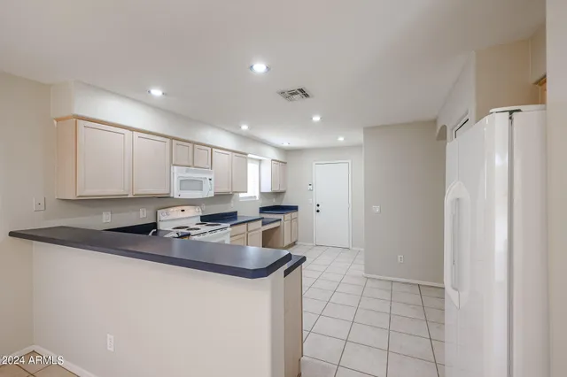 a kitchen with stainless steel appliances granite countertop a sink a stove a refrigerator a microwave and cabinets