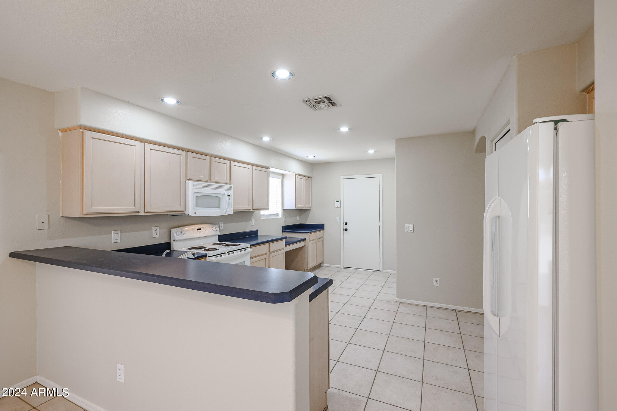 6921 West Juniper Avenue Peoria, AZ 85382 - Photo 9 of 33 a kitchen with stainless steel appliances granite countertop a sink a stove a refrigerator a microwave and cabinets