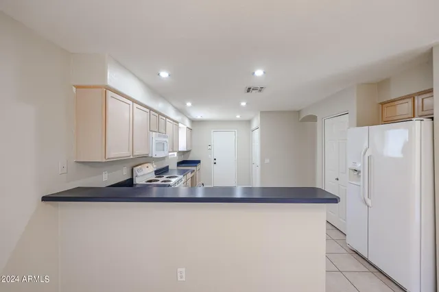 a kitchen with stainless steel appliances granite countertop a refrigerator a sink and a stove