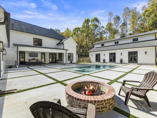 a swimming pool with outdoor seating and yard