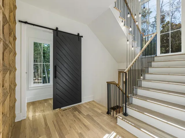 a view of a hallway with wooden floor and stairs
