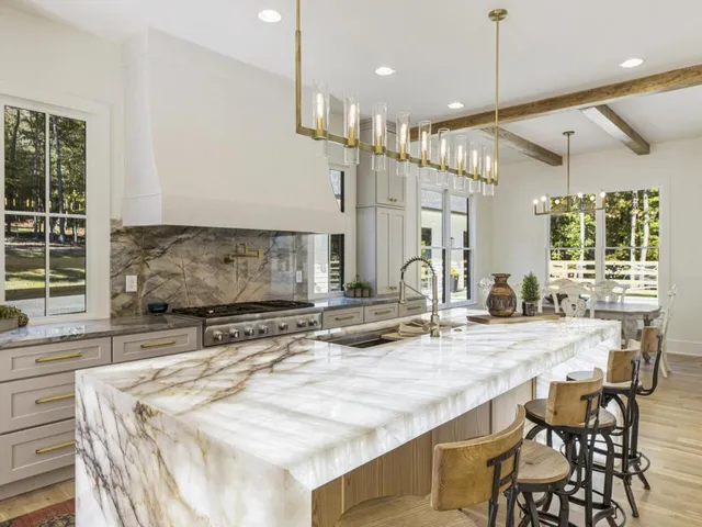 a large kitchen with kitchen island a sink table and chairs