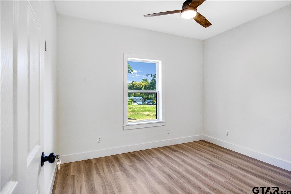 6600 Lionheart Drive Tyler, TX 75708 - Photo 19 of 32 an empty room with a window and wooden floor