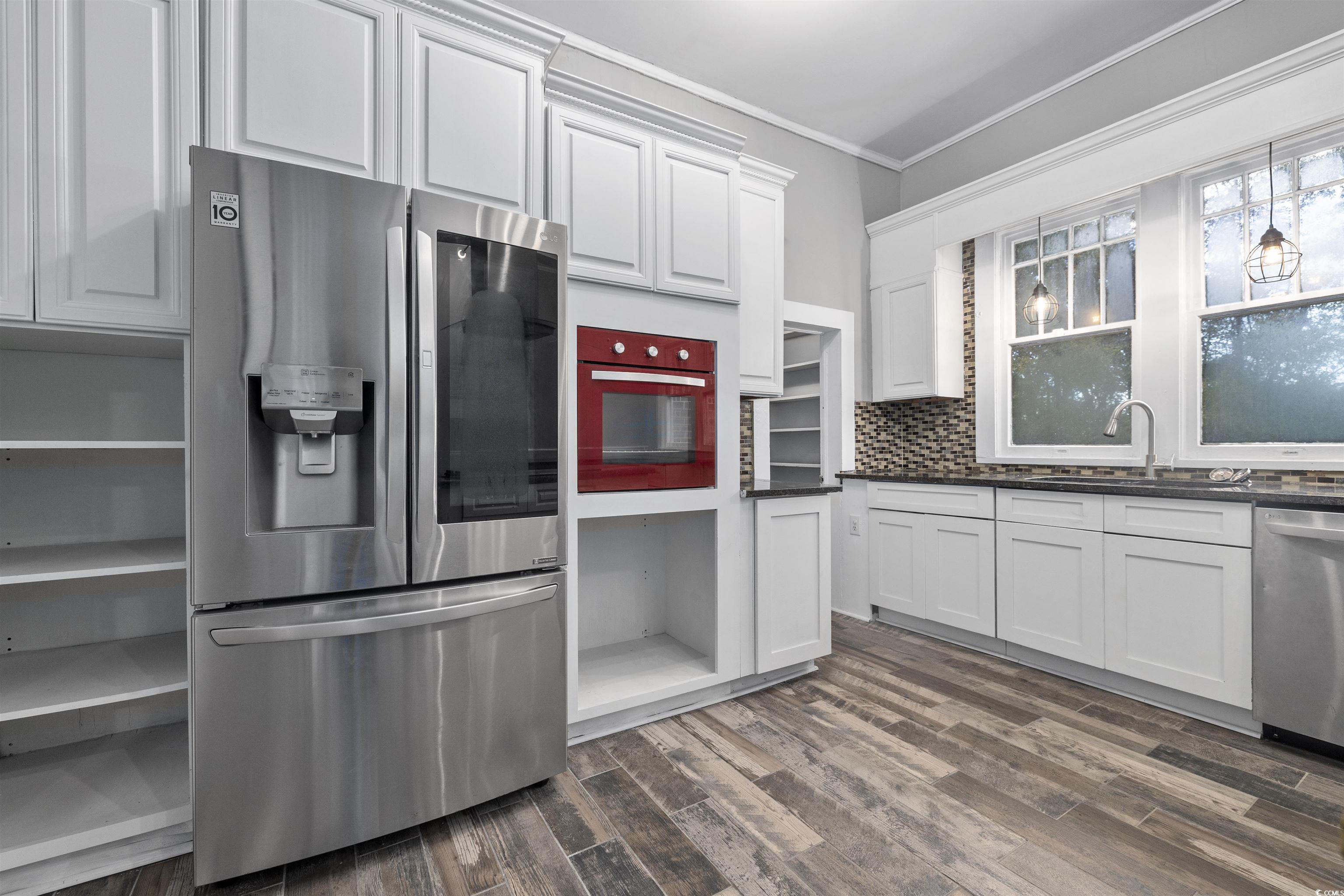 205 South Nichols Street Nichols, SC 29581 - Photo 11 of 27 Kitchen featuring white cabinets, sink, dark hardwood / wood-style floors, ornamental molding, and appliances with stainless steel finishes