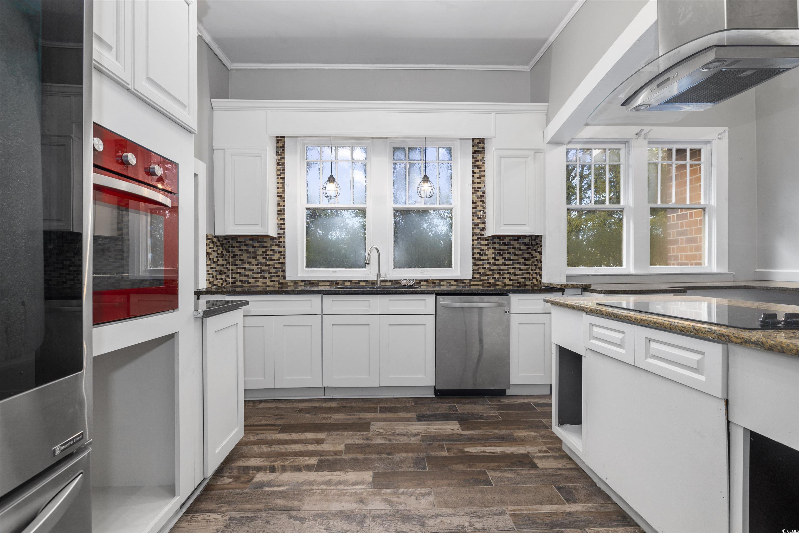 205 South Nichols Street Nichols, SC 29581 - Photo 13 of 27 Kitchen featuring backsplash, white cabinets, oven, and dark hardwood / wood-style floors