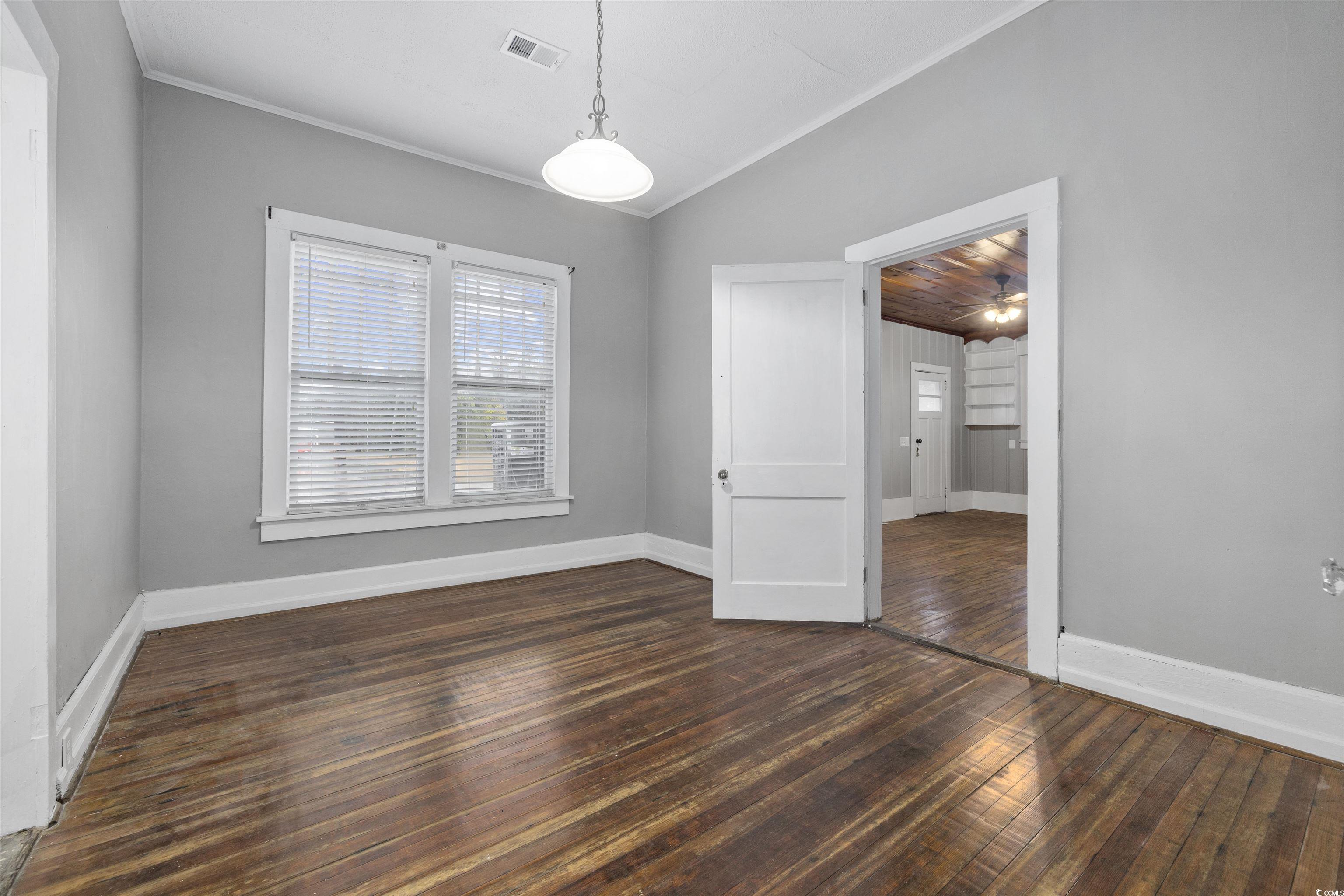 205 South Nichols Street Nichols, SC 29581 - Photo 17 of 27 Spare room featuring crown molding, dark wood-type flooring, and vaulted ceiling