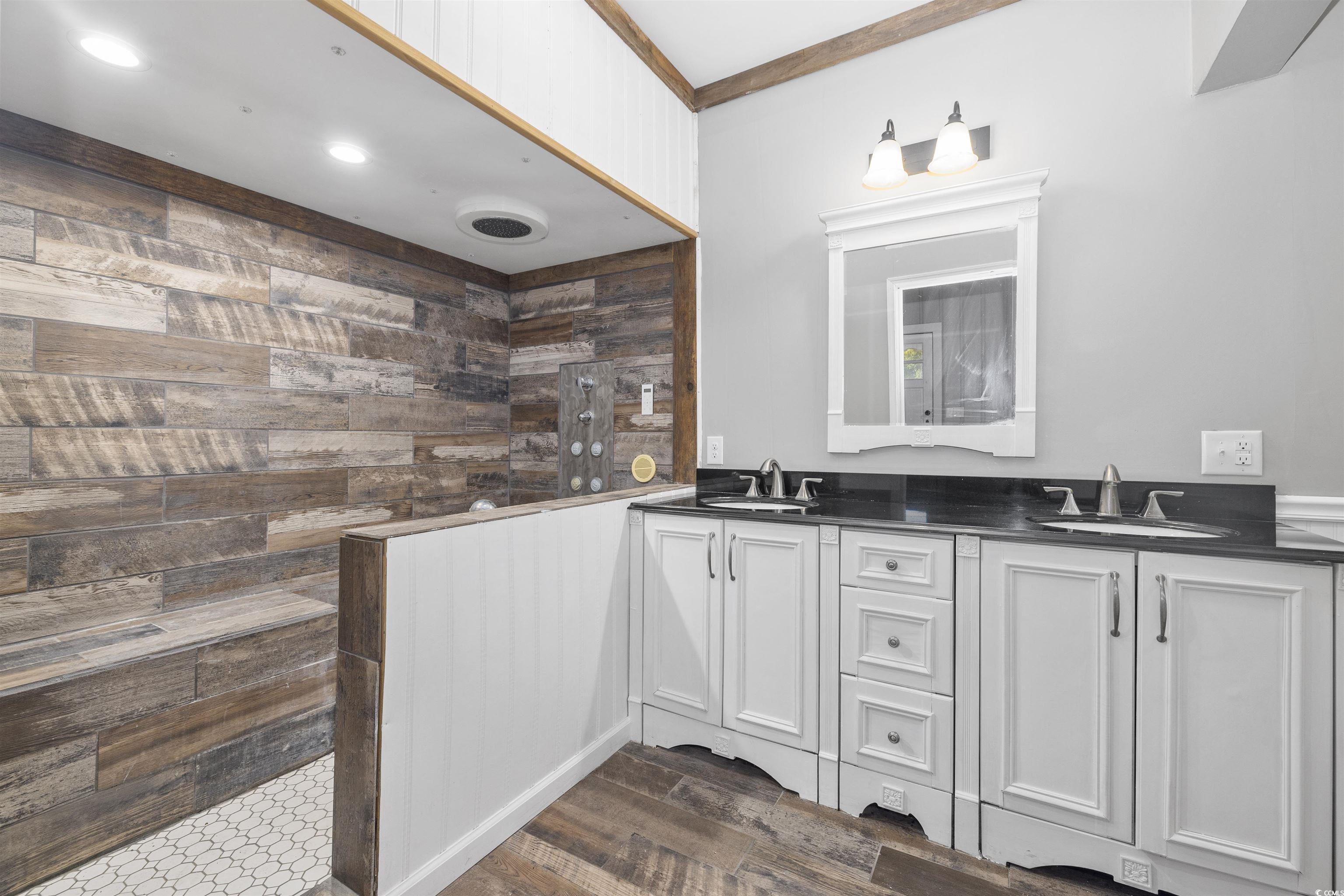 205 South Nichols Street Nichols, SC 29581 - Photo 20 of 27 Bathroom featuring vanity, wood walls, a shower, crown molding, and wood-type flooring