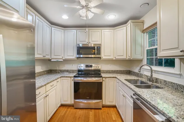 a kitchen with stainless steel appliances granite countertop a stove sink and cabinets